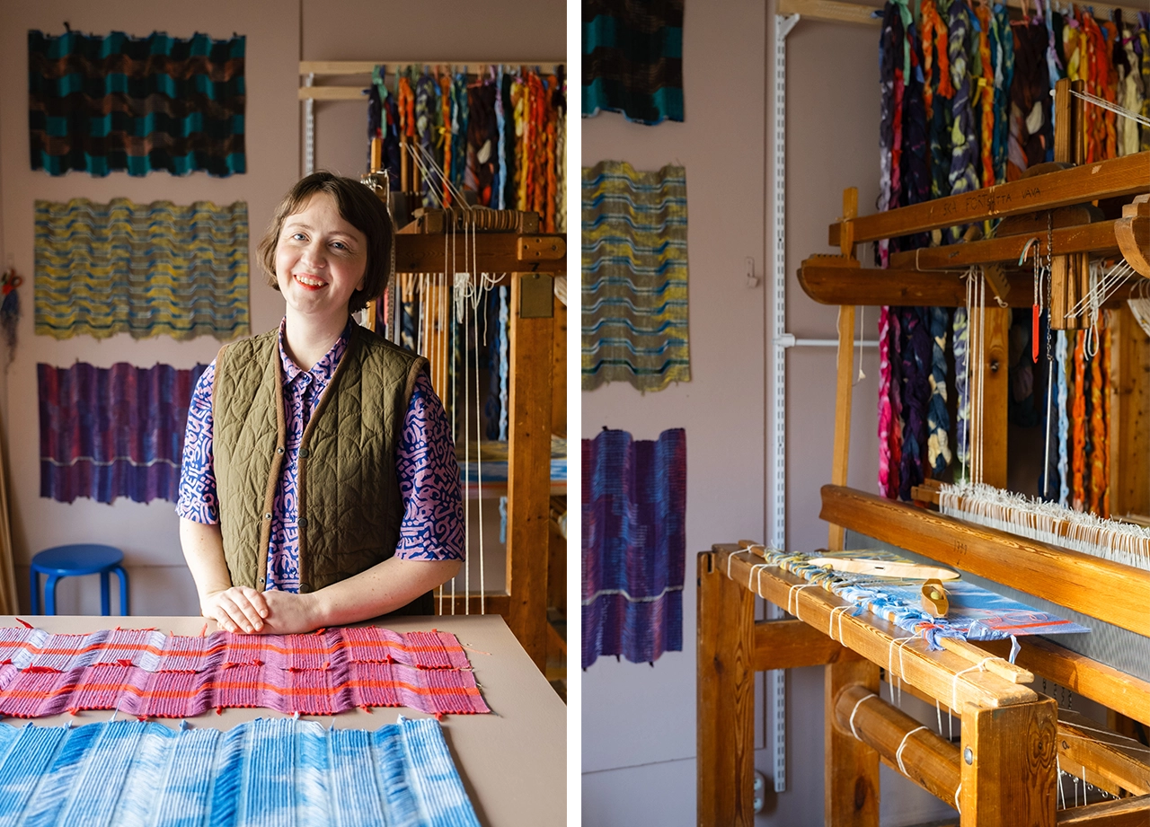 Emma Holmgren i sin ateljé framför ett bord med hennes vävar på och en vävstol bredvid.
