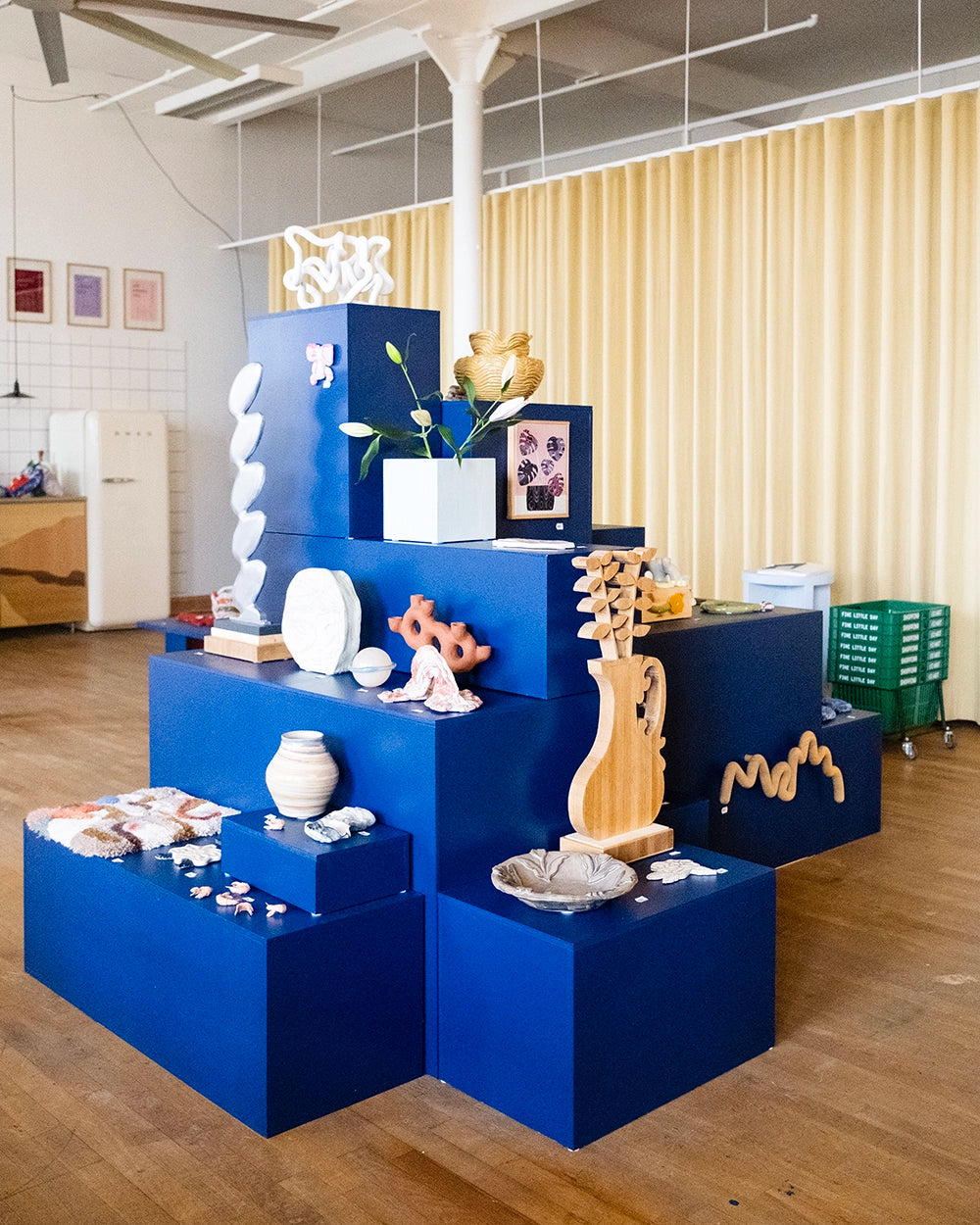 FLD Gallery, gallerirummet fylld med ett stort, blått podium med olika nivåer där flera konstobjekt står.